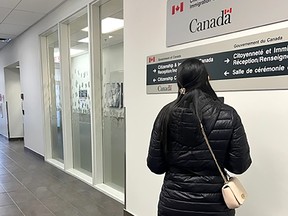Luz speaks into an intercom at the immigration offices at Calgary’s Harry Hays building and is told to phone Ottawa to make an appointment.