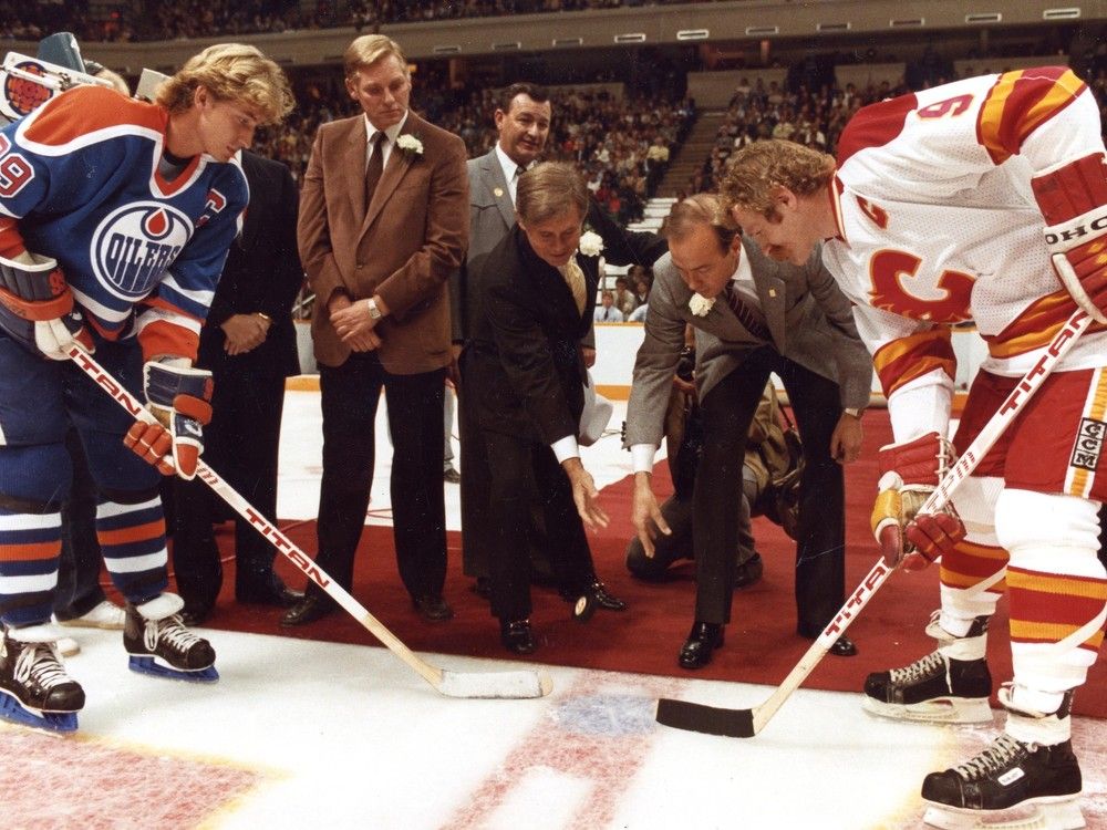 NHL President John Ziegler, left, and Calgary Olympic boss Frank King drop the puck between the Edmonton Oilers' Wayne Gretzky and Calgary Flames' Lanny McDonald on Oct. 15, 1983.