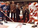 NHL President John Ziegler, left, and Calgary Olympic boss Frank King drop the puck between Edmonton Oilers' Wayne Gretzky and Calgary Flames' Lanny McDonald on Oct. 15, 1983.