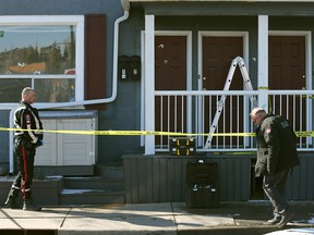 Calgary police gather evidence where bullets struck a residence near a shooting outside the Kensington Safeway on Wednesday.