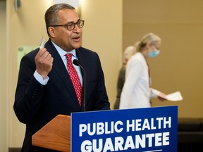 UCP Edmonton-Whitemud candidate dr. Raj Sherman holds up an Alberta health care map during a press conference where Danielle Smith announced the UCP's public health guarantee on April 11.
