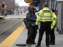 Third-party security guards respond to a man who fell onto the tracks at City Hall station on Monday.