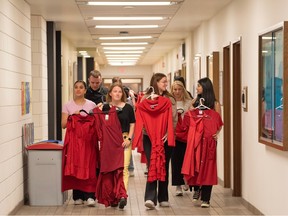 A group of nursing students at Mount Royal University carry red dresses to hang around the campus prior to national day of awareness for Missing and Murdered Indigenous Women (MMIW) on Thursday, May 4.