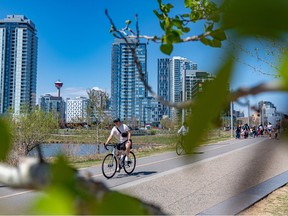 People enjoy the warm and sunny weather along the Bow River pathway in East Village on May 5.