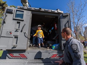 Three-year-old Theo and his father Jean-Luc Martin get to explore the Calgary Police Service's Armoured Rescue Vehicle during the Beacons of Hope event at Field of Crosses on May 14, 2022. Beacons of Hope is an initiative to honour The CPS and is returning for a second year.
