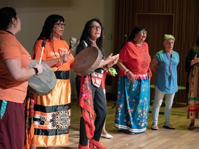 Members of the Sings Many Songs Women and members of the audience join to perform a song during the Indian Residential School memorial report to the community and validation ceremony at Calgary Central Library on Wednesday, May 31, 2023.