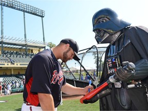 Atlanta Braves catcher Evan Gattis autographed a lightsaber bat for Darth Vader before a Braves spring training game at Champion Stadium at ESPN Wide World of Sports Complex in 2013 in Lake Buena Vista, Florida. Photo by Todd Anderson/Disney Parks via Getty Images.