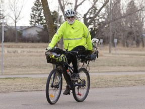 Dick Ensslen (80) and his dog Toby ride through the University of Alberta Farm in Edmonton, Thursday April 27, 2023. Ensslen is currently training for his 44th Ironman competition.