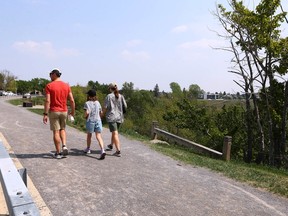 Walkers enjoy the weather at McHugh Bluff near Crescent Road N.W. in Calgary on May 19. Signs showing closure at the top of the hill have seemingly disappeared, despite warnings at the base of the hill.