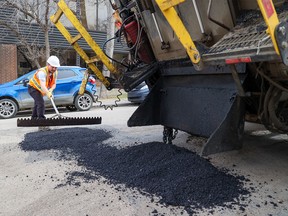 A City of Calgary roads crew fills potholes in Bankview on Tuesday, April 25, 2023.