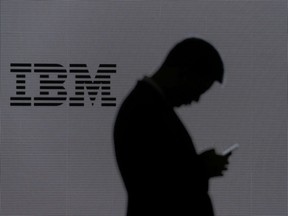 A man checks his mobile phone outside IBM's booth at the Mobile World Congress in Barcelona, Spain, February 28, 2018.