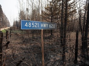 A burnt road sign and trees damaged by recent wildfires are shown in Drayton Valley, Alta. on Wednesday May 17, 2023. Special air quality statements from Environment Canada continue to cover most of Alberta as smoky air blankets much of the province.