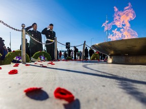 Soldiers salute after placing their poppies at the eternal flame outside the Military Museums during Remembrance Day in Calgary on Friday, November 11, 2022.