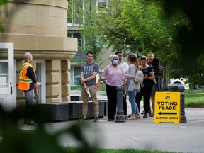 Voters line up to vote after work in the provincial election in Calgary, Alberta, May 29, 2023.