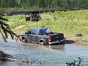 A naked man is seen attempting to retrieve his car from a Calgary-area river.