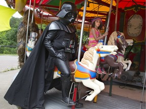 Six-year-old Mya Rasoulinejad cautiously rode the carousel at Storybook Gardens with Darth Vader during the park’s Star Wars Day in London, Ont. in 2017. The 8th annual Star Wars Day featured 16 costumed characters from local Star Wars enthusiast clubs. Postmedia archives.