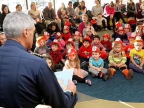 Calgary Fire Chief Steve Dongworth reads to kids at the Calgary Public Library.