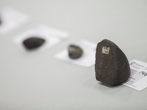 Scientists from Western University and NASA display some meteorites during a press conference in St.Thomas, Ont., Friday, March 21, 2014. On April 8, a fireball ripped through the Earth's atmosphere and landed somewhere in New Brunswick, prompting Maine Mineral and Gem Museum in Bethel to offer a US$25,000 reward for the first one kilogram meteorite recovered.