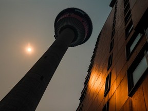 Wildfire smoke gives an orange cast to the noon sunlight, silhouetting the Calgary Tower on Wednesday.