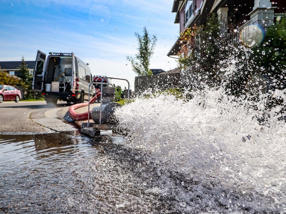 A City of Calgary crew flushes out a water main through an open fire hydrant to clear potential contaminated water following a large water main break near Silverado on Friday, June 2, 2023. The Silverado, Yorkville and Belmont communities were on a boil water advisory.