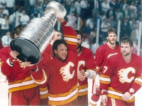 Mike Vernon holds the Stanley Cup and the Calgary Flames celebrate their 1989 championship win.