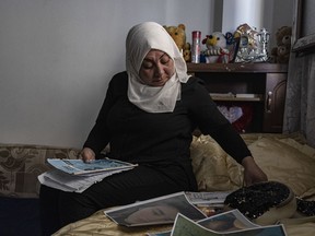 Hamrin Alouji, the mother of 13-year-old Peyal Aqil, goes through her daughter's photographs at their family home in Qamishli, Syria, on Monday, June 5, 2023. Alouji said her daughter was coming home with her friends on May 21 after a school exam when a recruiter for the Revolutionary Youth approached her - the youth branch of the Democratic Union Party (PYD), and entered a center belonging to the group with him. Her friends waited for her outside, but she never came out.