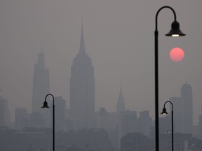 The sun rises over a hazy New York City skyline as seen from Jersey City, N.J., Wednesday, June 7, 2023.