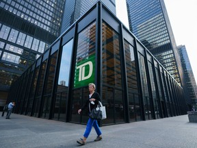 A person walks past a TD Bank sign in the financial district in Toronto on Tuesday, Sept. 20, 2022. TD Bank Group says its direct deposit system has been hit by technical issue that is preventing account holders from getting paid.