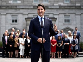 Prime Minister Justin Trudeau gestures towards the federal cabinet as they stand behind him at a media availability after a cabinet shuffle, at Rideau Hall in Ottawa, on Wednesday, July 26, 2023.