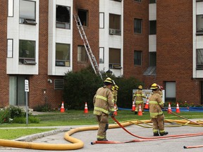 Firefighters work at the Mountview Senior Citizens Apartments at 16 Avenue and 6 Street N.E. in Calgary after a fire in the building on Thursday, July 27, 2023.