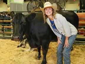 Clara Blatz was photographed with black Angus cow Felicity in the Nutrien Event Centre at the Calgary Stampede on Tuesday, July 11, 2023.