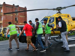 People unload the body of victim who killed in a helicopter crash, at Tribhuvan University Teaching Hospital in Kathmandu on July 11, 2023.