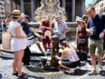 People queue to fill bottle with water at a public tap at Piazza della Rotonda in Rome. For many critics, the school janitor case reflects the casual sexism and objectification of young women that is still widespread in Italy.