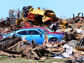 RCMP survey damage on Sunday, July 2, 2023, after a tornado destroyed property on Highway 2A between Didsbury and Carstairs the day before.