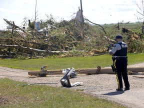 RCMP survey damage on Sunday, July 2, 2023, after a tornado destroyed property on Highway 2A between Didsbury and Carstairs the day before.