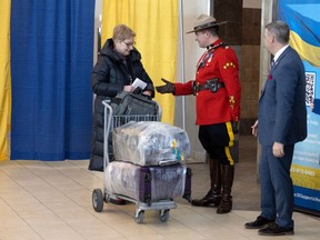 An RCMP officer welcomes a Ukrainian immigrant to Canada in March 2023.