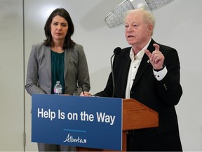 Premier Danielle Smith listens as Dr. John Cowell, official administrator with AHS answers questions during a press conference on a new initiative to use alternative modes of transportation for non-emergency transfers to hospital. The goal is to help free up paramedics and ambulances for emergency calls. The announcement took place in a training lab at the Cal Wenzel Precision Health Building next to the Foothills Hospital on Wednesday, December 21, 2022. Gavin Young/Postmedia