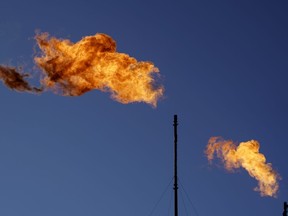 Flares burn off methane and other hydrocarbons at an oil and gas facility in Lenorah, Texas, Friday, Oct. 15, 2021. New research on Canada's methane emissions concludes it would be much cheaper for the energy industry to meet reduction targets for the potent greenhouse gas than it would be to pay carbon taxes on it.