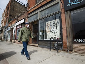 A closed store front boutique business called Francis Watson pleads for help displaying a sign in Toronto in 2020.
