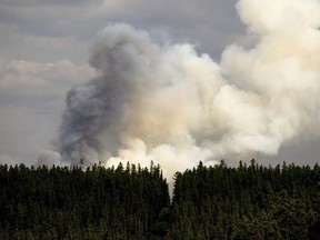Smoke billows from the Donnie Creek wildfire burning north of Fort St. John, British Columbia, on Sunday, July 2, 2023. The young Ontario firefighter who died last week in British Columbia has been identified as Zak Muise in an online obituary and tribute by the firefighting contractor he worked for.