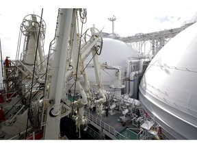 Workers connect a liquefied natural gas (LNG) transfer pipe to the LNG tanker Sohshu Maru, berthed at Jera Co.'s Futtsu Thermal Power Station in Futtsu, Chiba Prefecture, Japan, on Friday, Dec. 17, 2021. North Asia spot LNG prices hovered near $40/mmbtu, with buyers in the region satisfied by inventory levels heading into winter, while European prices traded at a premium to Asian values for a third day. Photographer: Kiyoshi Ota/Bloomberg