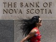 A person makes their way past a Bank of Nova Scotia, formally known as Scotiabank, building in the Financial District of Toronto, Monday, Aug. 14, 2023.