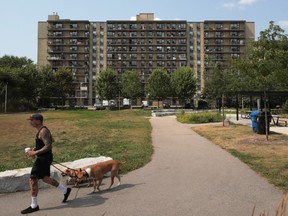 A pedestrian walks dogs outside an apartment building in the Parkdale neighborhood of Toronto, Ontario, Canada, on Friday, Aug. 20, 2021.