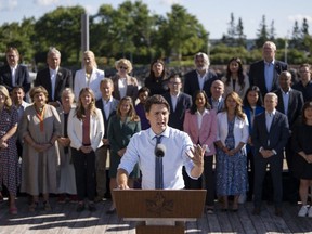 Prime Minister Justin Trudeau speaks to reporters as cabinet members look on during the Liberal cabinet retreat in Charlottetown, P.E.I. on Wednesday, August 23, 2023.