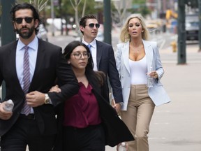 FILE : The son, left, and daughter, back right, of Pittsburgh dentist Lawrence "Larry" Rudolph head into federal court for the afternoon session of the trial, July 13, 2022, in Denver. Rudolph, a wealthy dentist convicted of killing his wife during an African safari so he could be with his girlfriend, is expected to be sentenced to life in prison Monday, Aug. 21, 2023, for a murder prosecutors say capped off a lifetime "spent seeking domination and control over others through wealth and power." The couple's two adult children, Julian and AnaBianca Rudolph, have so far opted not to to speak publicly about the death.