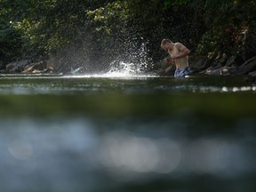 A person cools off in Lynn Creek in North Vancouver, B.C., on Thursday, July 6, 2023. Health authorities as well as local and provincial governments across British Columbia are providing guidance on how best to deal with a sweltering heat wave that began in British Columbia's southern coast this weekend is expected to expand into the Interior starting today.THE CANADIAN PRESS/Darryl Dyck