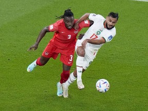 Canada's Sam Adekugbe and Morocco's Sofiane Boufal vie for the ball during the World Cup group F soccer match between Canada and Morocco at the Al Thumama Stadium in Doha , Qatar, Thursday, Dec. 1, 2022. The Vancouver Whitecaps acquired the Canadian defender via transfer from Turkish side Hatayspor on Thursday.