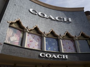 FILE - This photo shows a Coach retail shop at the Citadel Outlets in Commerce, Calif., on May 3, 2019. Tapestry, parent company of luxury handbag and accessories retailer Coach, is buying the owner of fashion brands including Michael Kors, Versace and Jimmy Choo, Capri Holdings. The approximately $8.5 billion deal puts Tapestry in a better position to take on its big European fashion rivals.