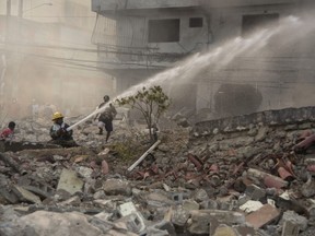 Firefighters put out a fire after a powerful explosion in San Cristobal, Dominican Republic, Monday, Aug 14, 2023. The Monday afternoon explosion killed at least three people and injured more than 30 others, authorities said.