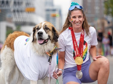 Team Canada speed skater Ivanie Blondin poses for a photo with her dog Brooke while wearing her Olympic medals at the Calgary Pride Parade in downtown Calgary on Sunday, September 3, 2023.
